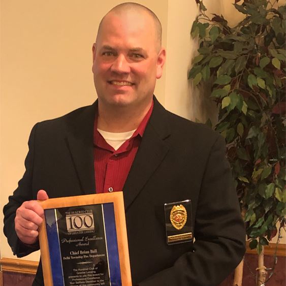 Chief Brian Ball holding the award plaque.