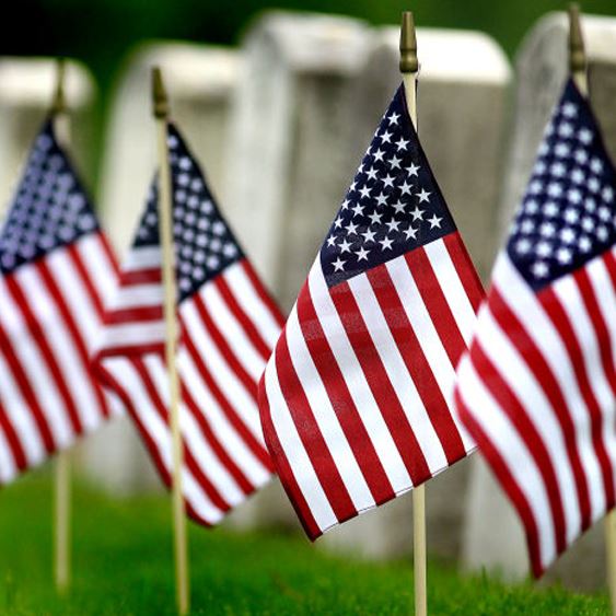 Small U.S. flags in the ground at a cemetery